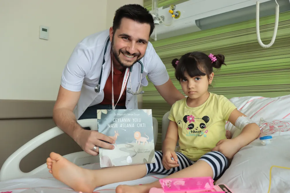 Çocuk doktoru yazdığı hikaye kitabını servis servis gezerek çocuklara okuyor